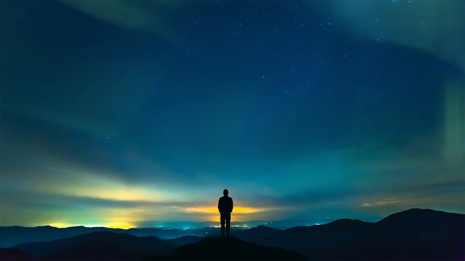 Northern lights over a mountain landscape — QX World hero background